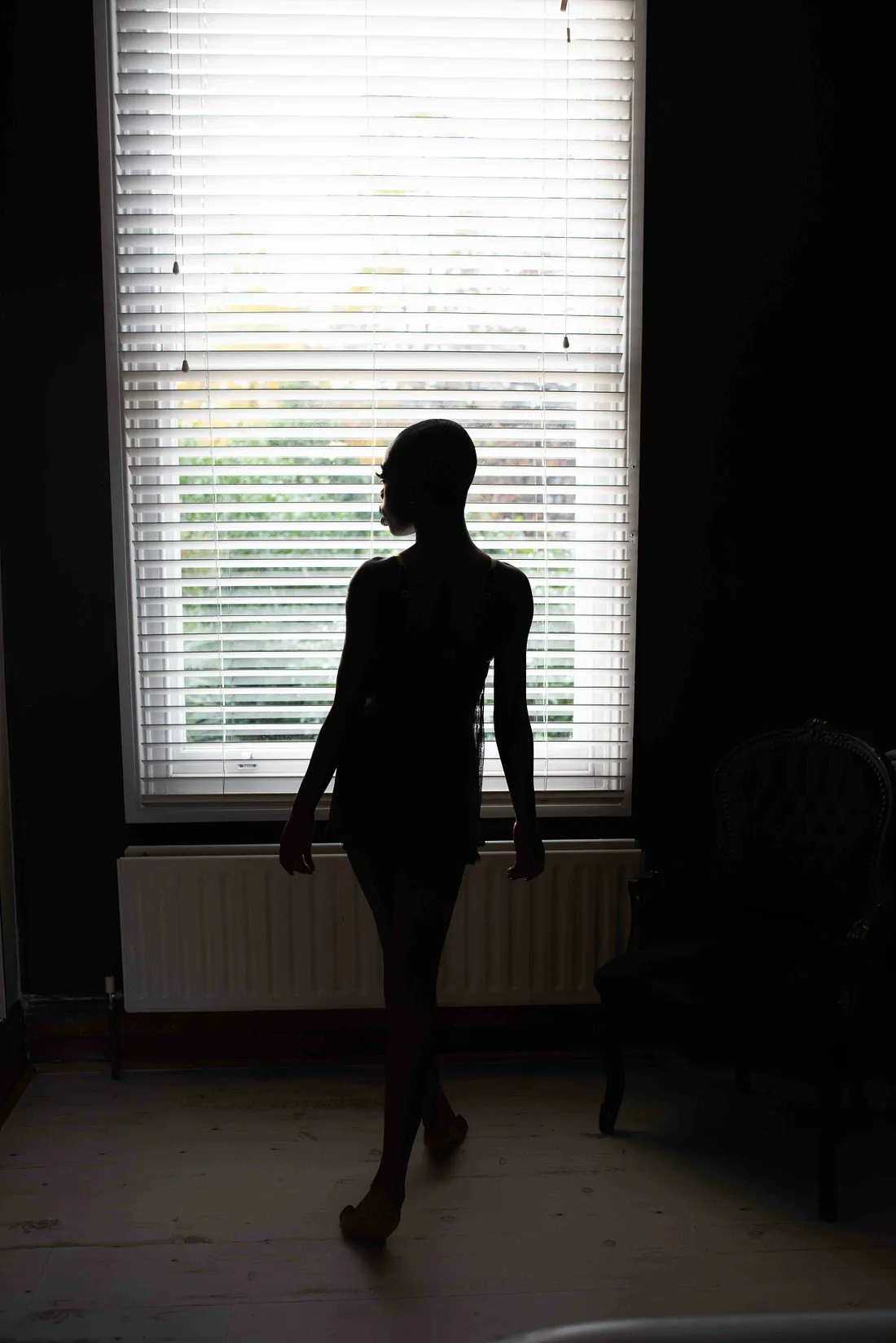 She stands, a silhouette against the light